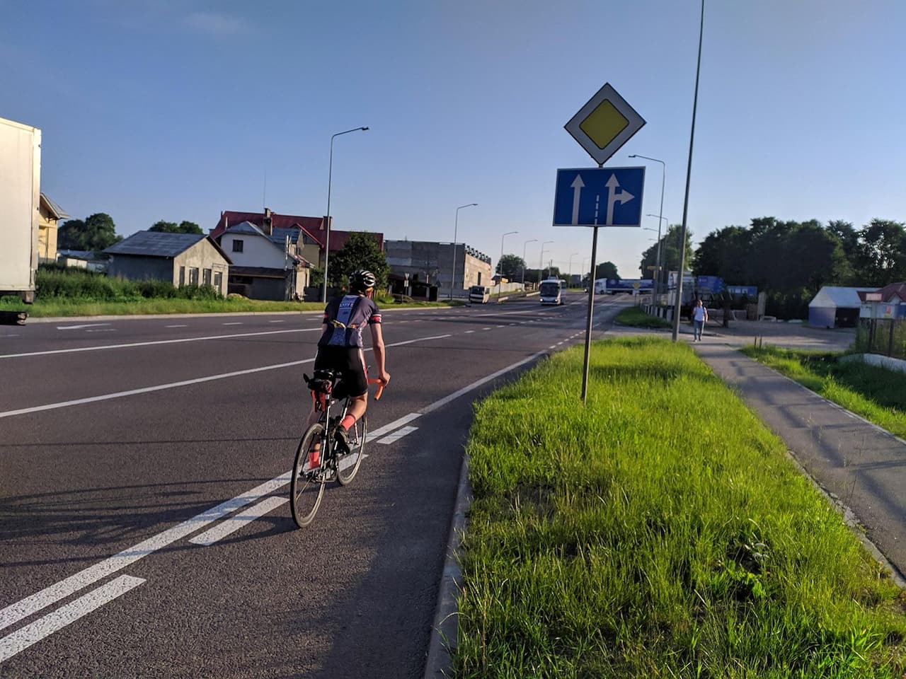Чоловік їде на велосипеді збоку дороги