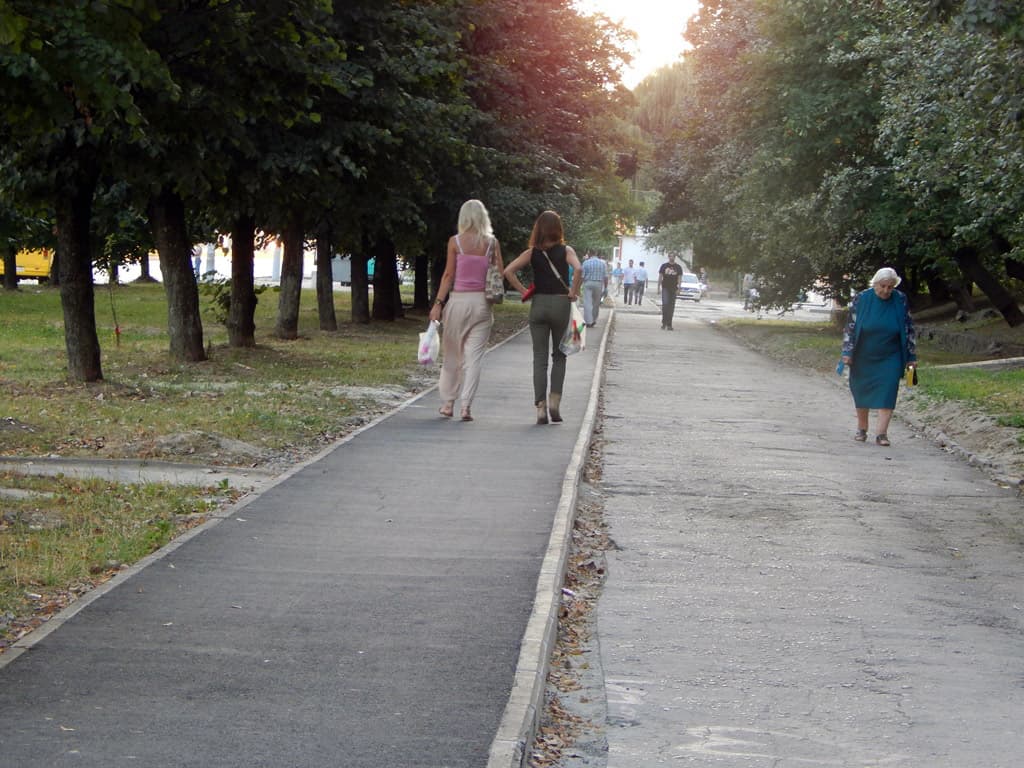 Група людей, які йдуть вниз по тротуару