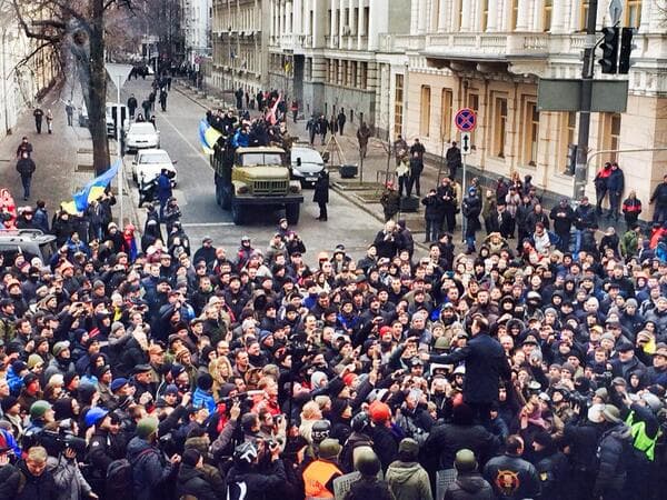 Група людей, що йдуть перед великим натовпом людей