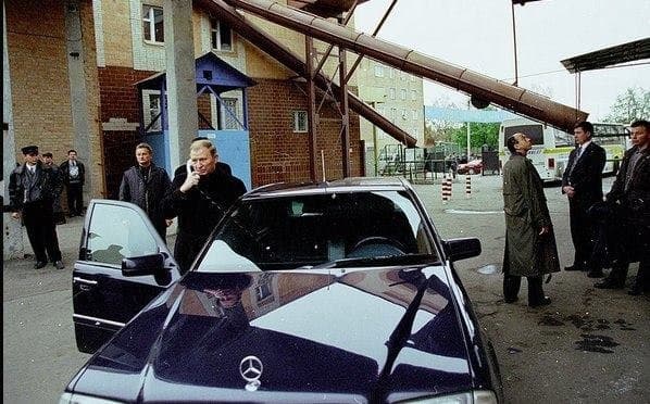 Група людей, що стоять поруч з автомобілем