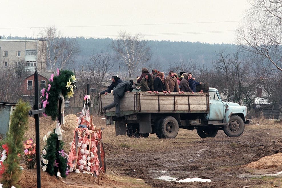 Група людей, які їдуть на задній частині вантажівки