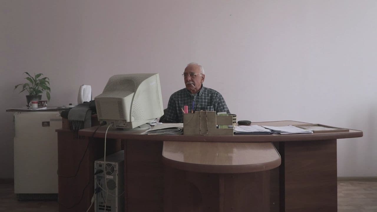 Людина, яка сидить за столом з ноутбуком