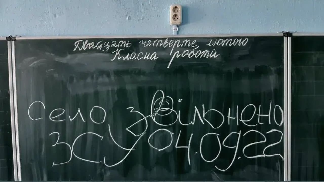 Вивіска на дошці з графіті збоку будівлі