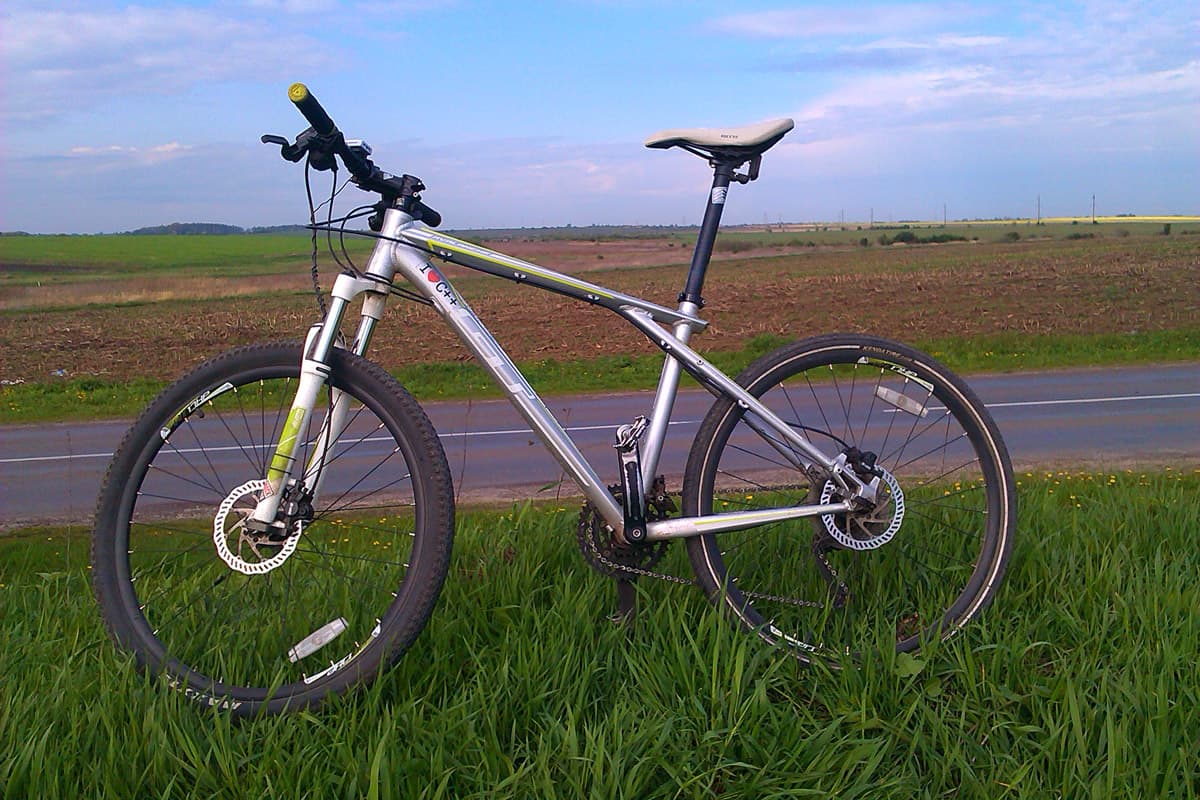 Велосипед, припаркований на боці пишної зеленої області