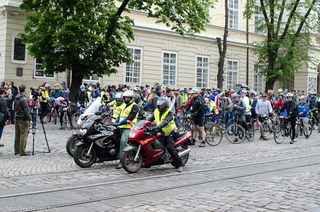 Група людей на мотоциклі перед будівлею
