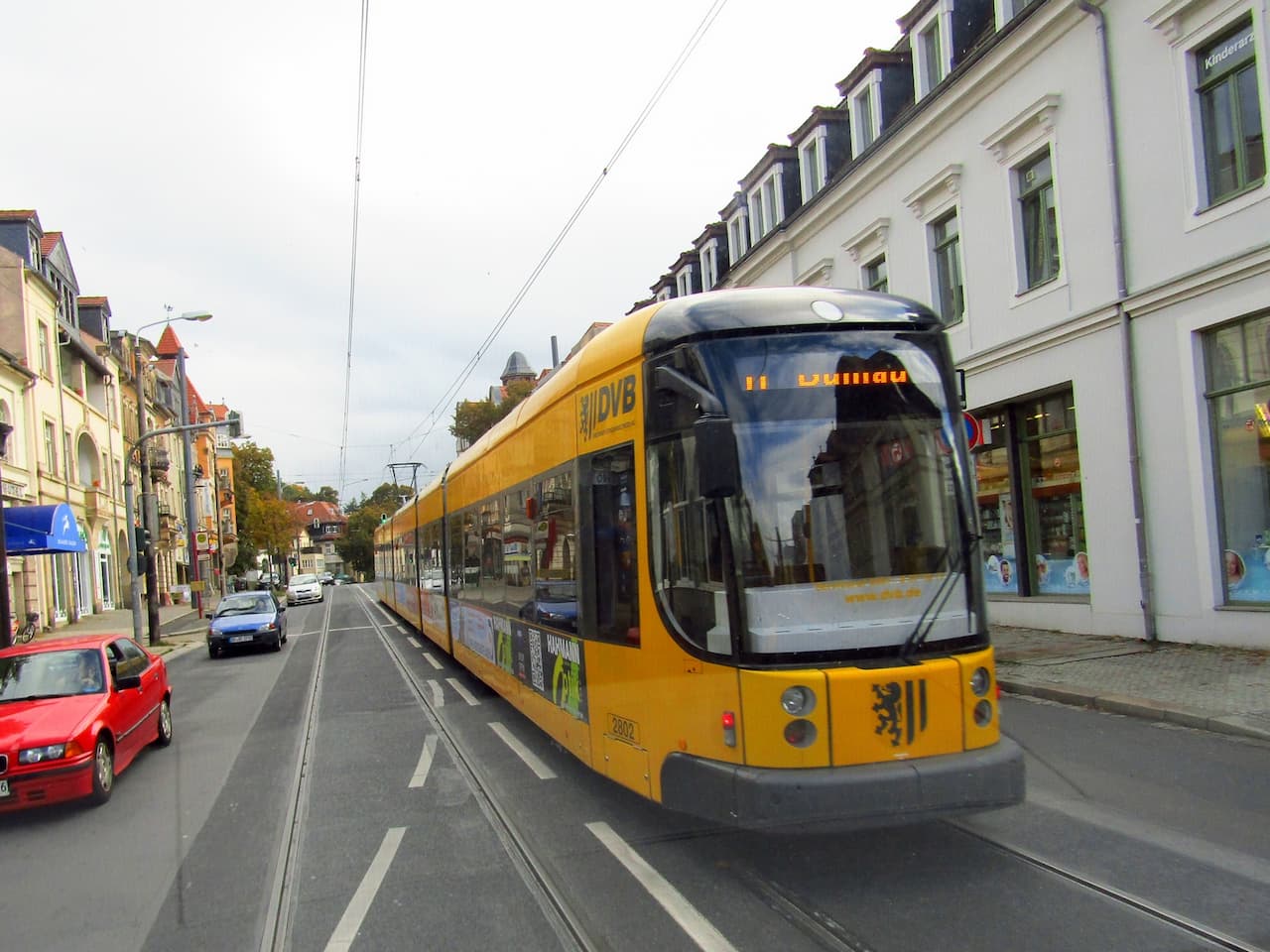 Жовта автобусна проїжджаючи вниз по вулиці