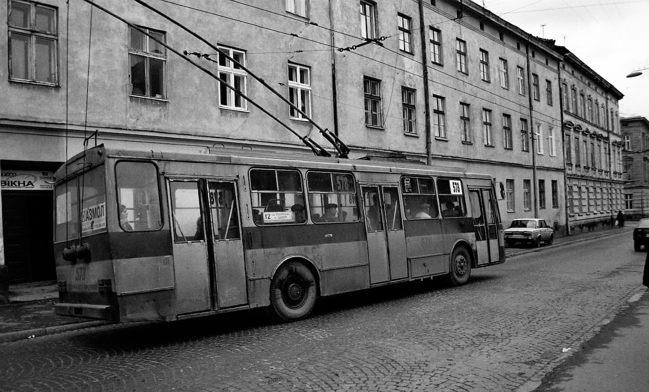 Старий автобус припаркований на стороні будівлі