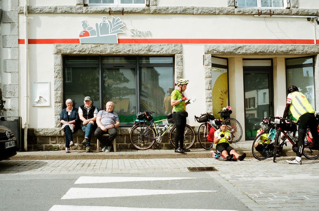 Місцеві пенсіонери спостерігають за велосипедистами