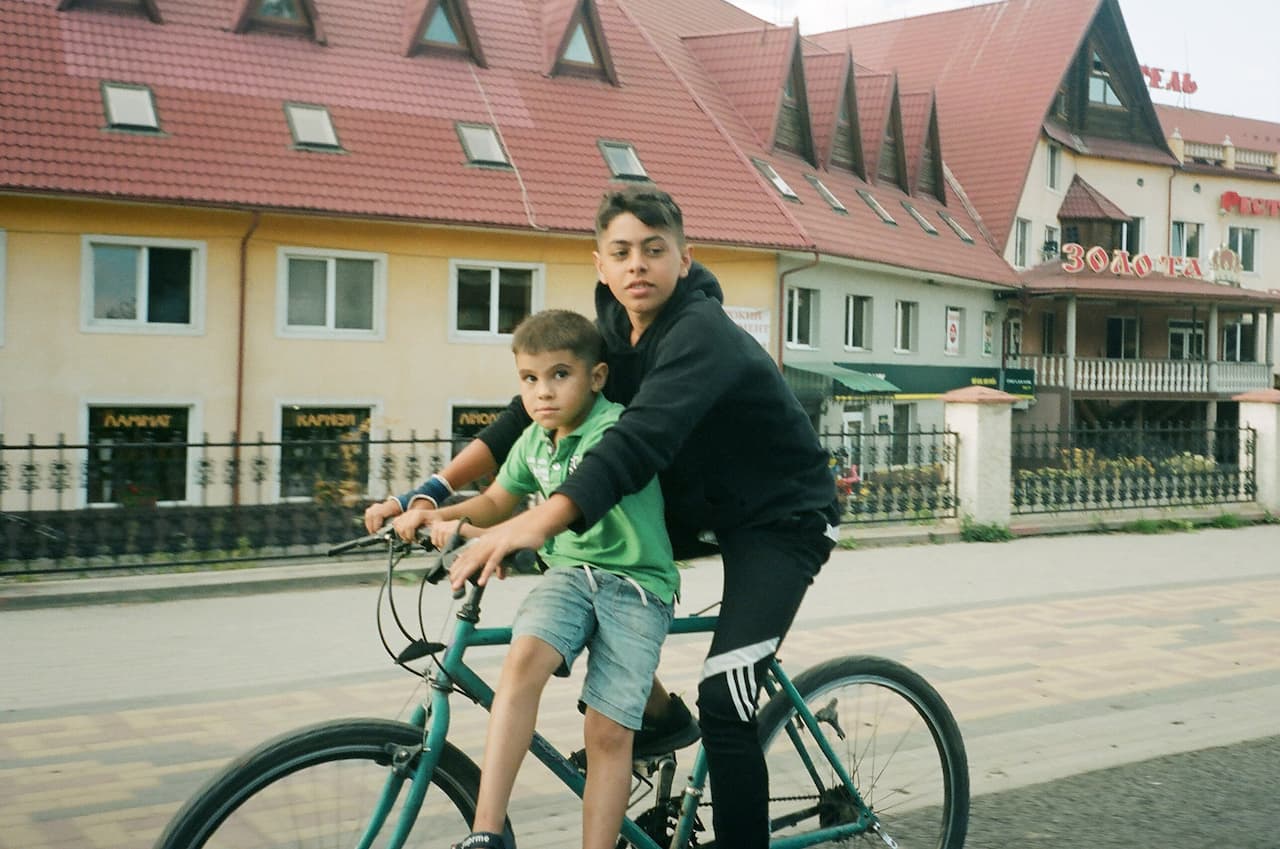 Молодий хлопець їздить на велосипеді перед будівлею